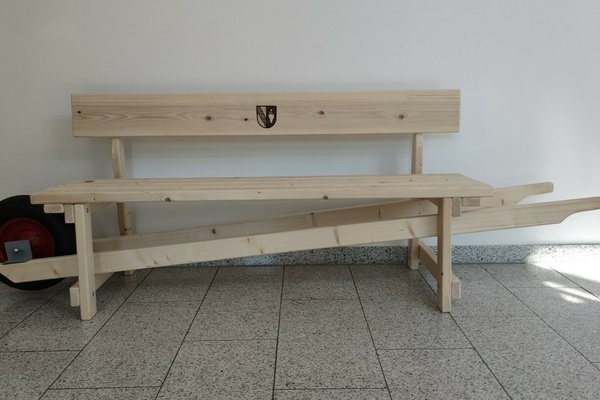 Schwtzbnkle aus Holz mit dem Denzlinger Wappen auf der Rckenlehne