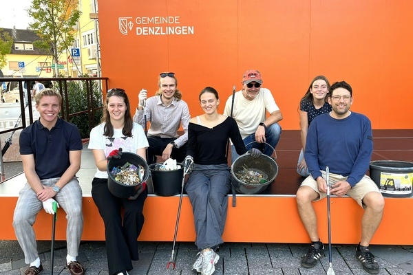 Foto der M&uuml;llesammelaktion des JGR Denzlingen. Menschen auf einem orangefarbenen Podest mit M&uuml;llzangen und Eimern mit Unrat. Foto: JGR Denzlingen
